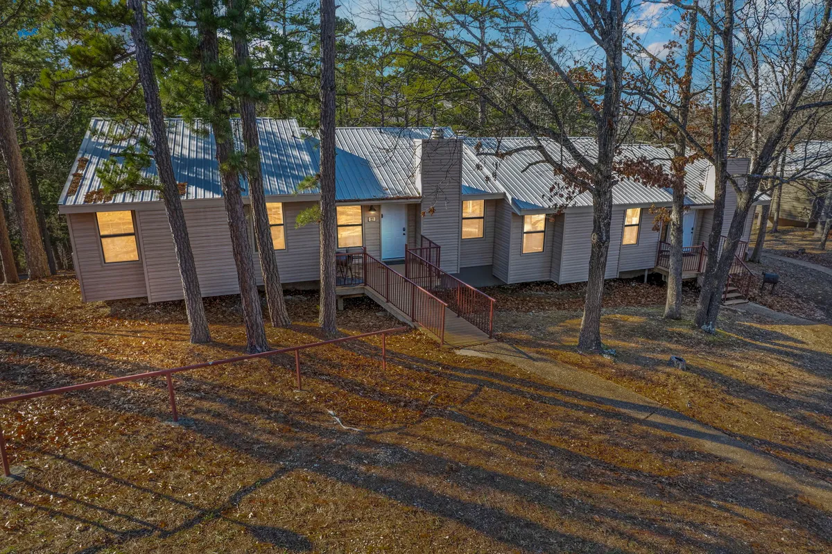 The welcoming exterior of the house framed by mature trees and a clear pathway, suggesting space for group gatherings and a sense of togetherness in a scenic, natural environment.